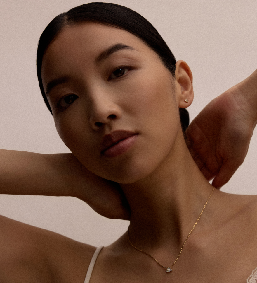 Model wearing Ajour pendant in 18k gold with triangular diamond pavé